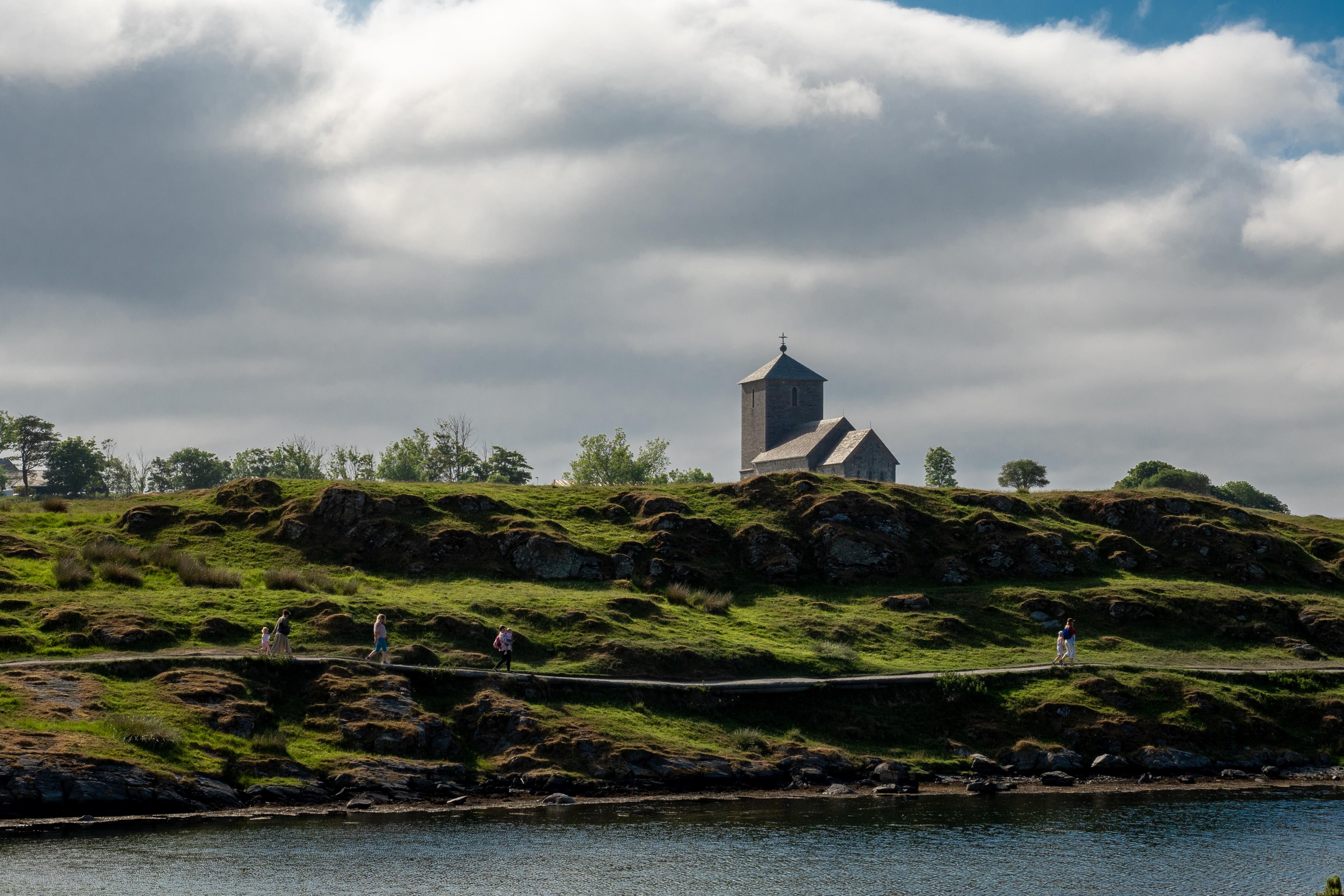 Kulturlandskap med sti på Avaldsnes. Olavskirken i bakgrunnen.