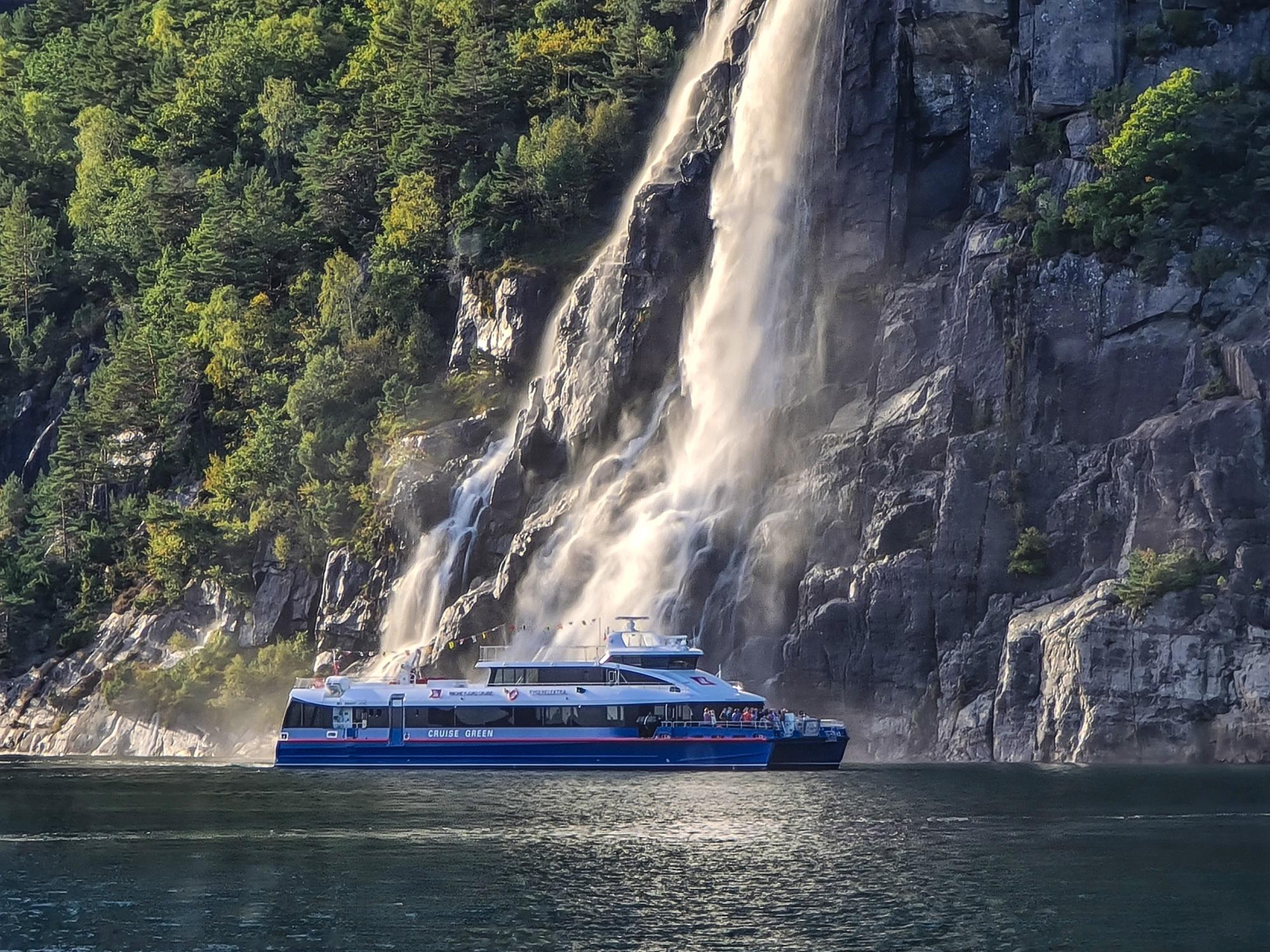 En sightseeingbåt som ligger på fjorden foran Hengjanefossen.