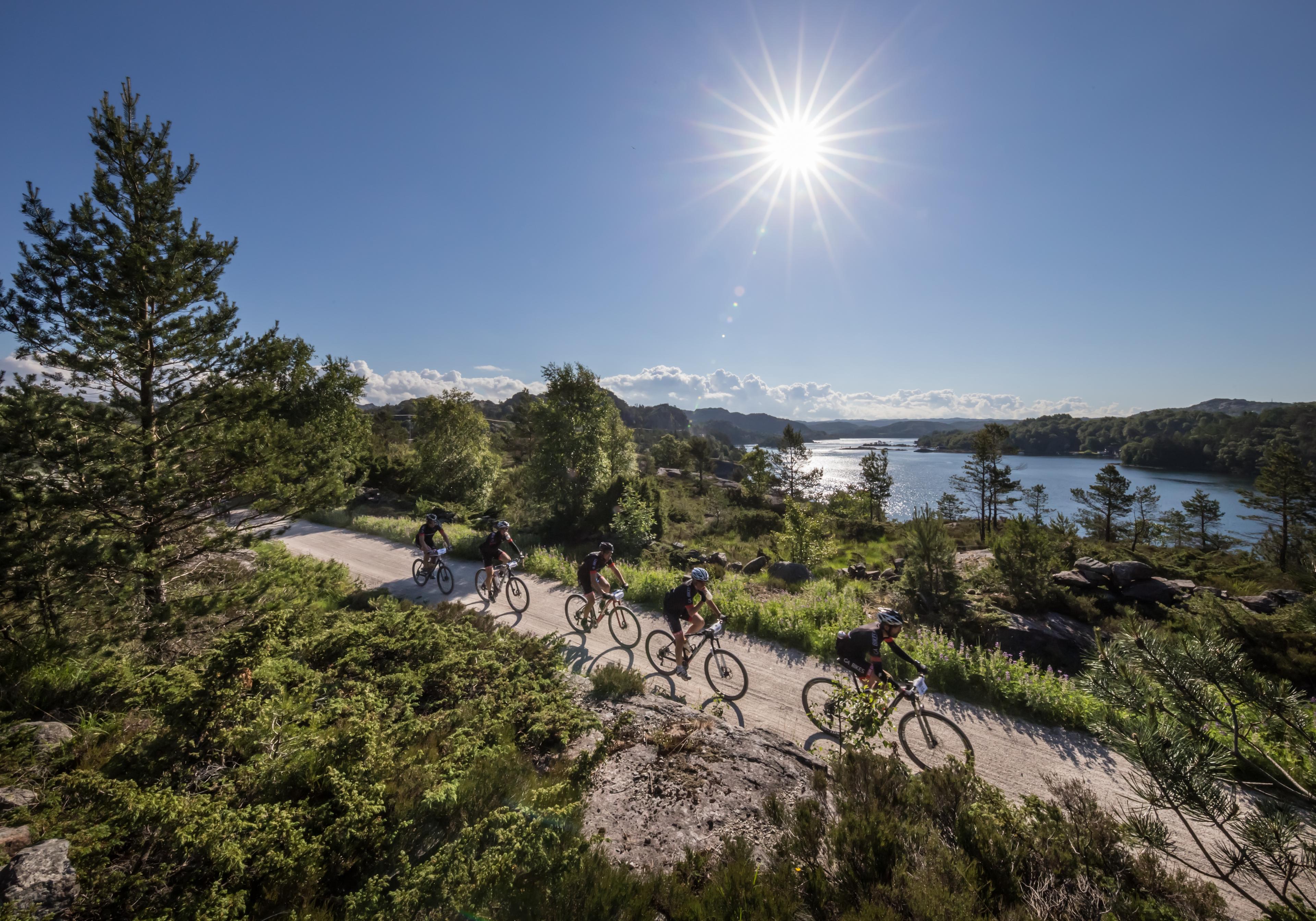 Person sykler sykkelrittet Nordsjørittet i fin natur i strålende sol.