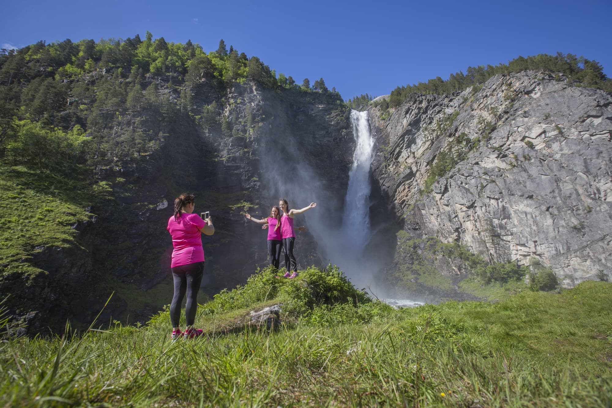 Mor fotograferer døtrene sine foran Åmotan