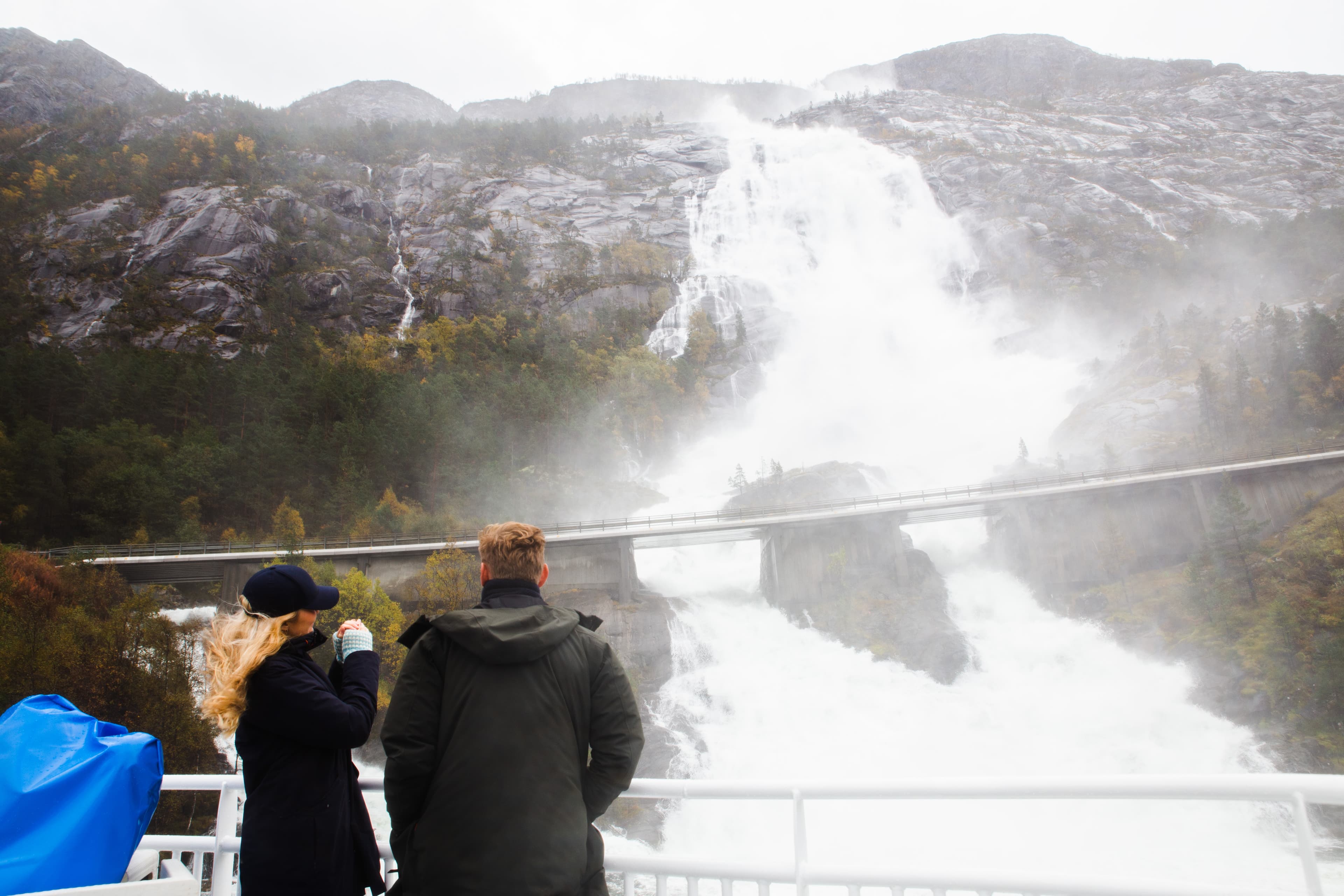 Langfoss sett fra båt på Åkrafjorden, mann og dame på tur.