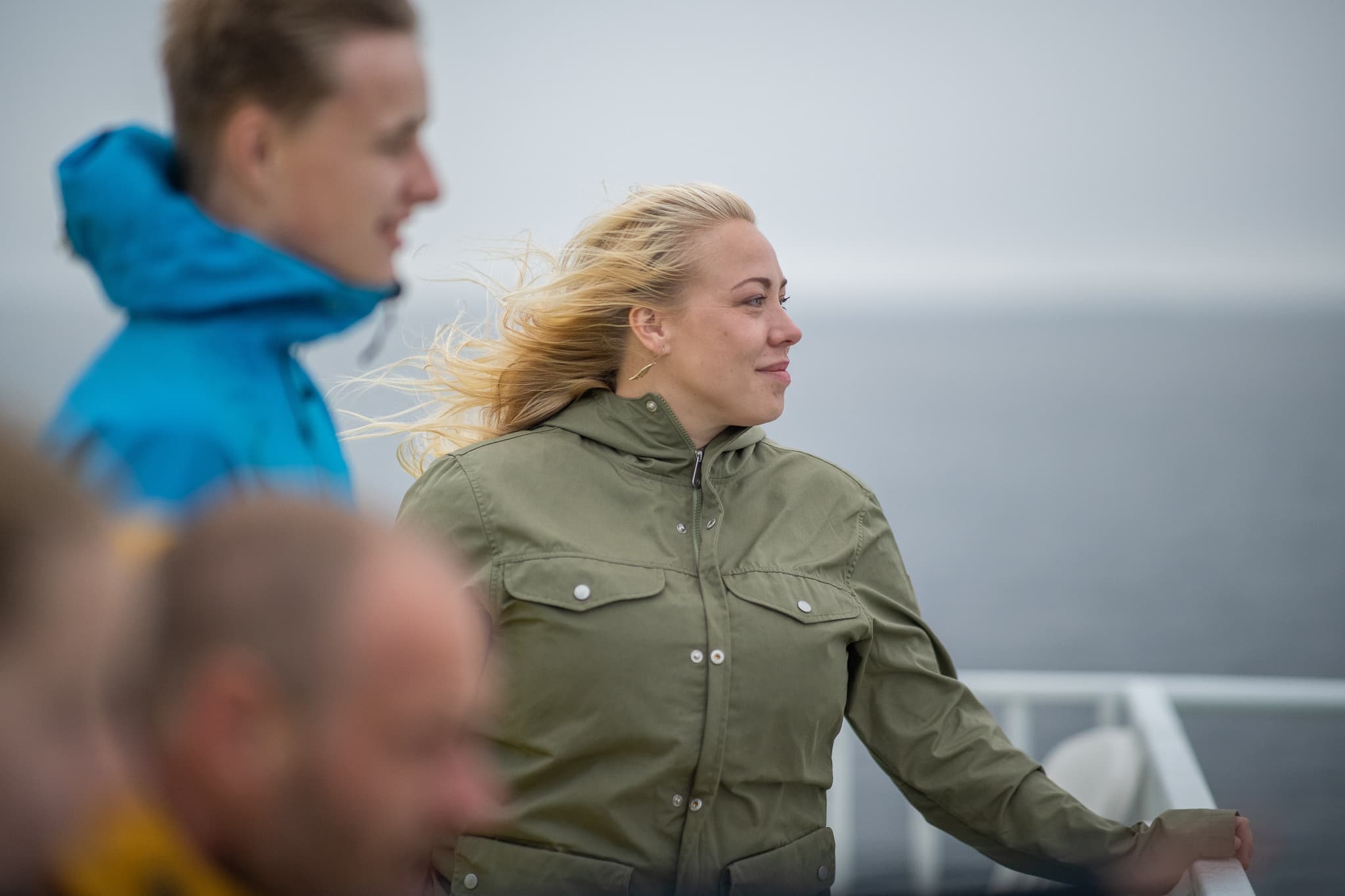 A family of four on a ferry deck looking out at sea