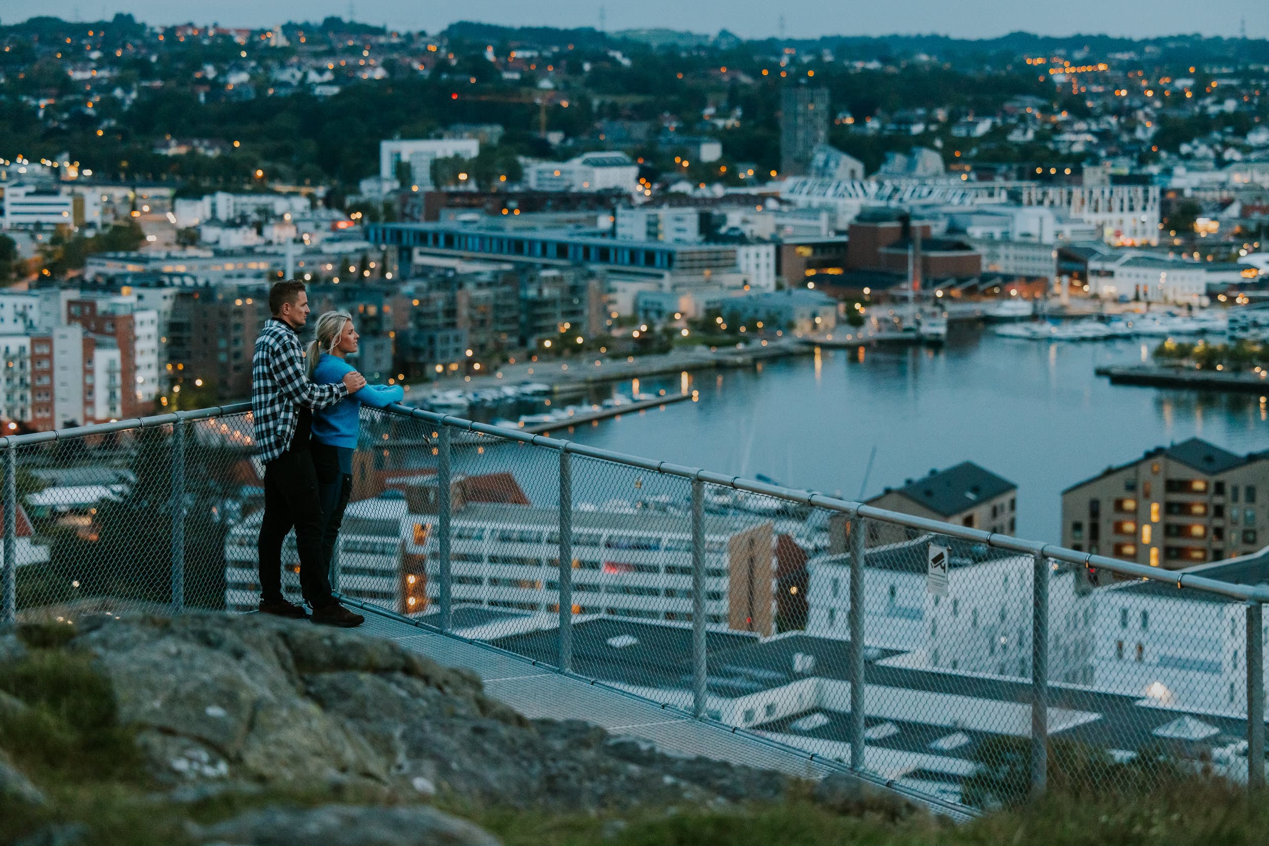 Two people and a dog looking at the view from the top of mountain hanafjellet Hanatrappene